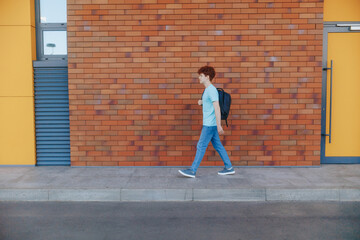 Teenage Redhead Student Walking Calmly Along Urban Wall