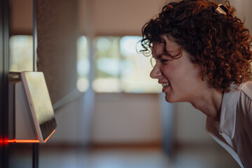 Businesswoman using biometric eye scan access control at office