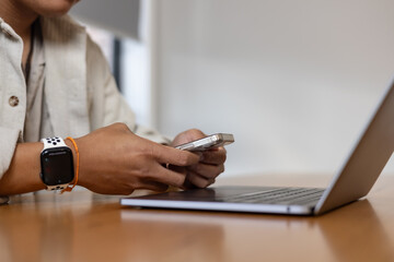 man using smartphone at home, messaging or browsing social networks while relaxing on couch