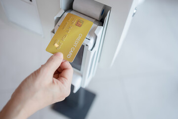Close up image of a woman holding a creditcard and a payment transaction to bank payment terminal