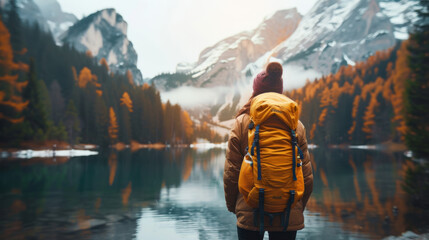 Woman in nature contemplating the mountains and lake view in autumn. Hiking adventure travel.