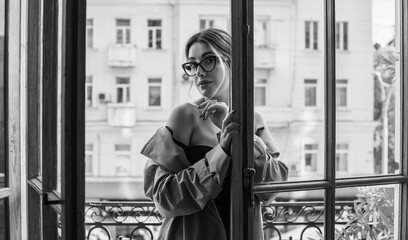 Lady in beige coat, stockings and black lingerie. Sensual photo of European Blonde woman on a...