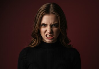 Naklejka premium Portrait of a furious young woman with an angry face snarling and showing her white teeth