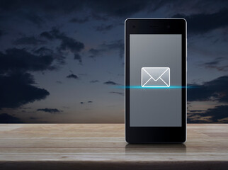 email flat icon on modern smart mobile phone screen on wooden table over sunset sky, Business...