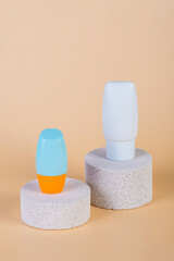 Cosmetic product in tube, bottle, lotion or serum with stylish props on cream background. 