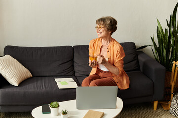 Senior woman enjoys a relaxing afternoon at home while sipping a refreshing drink