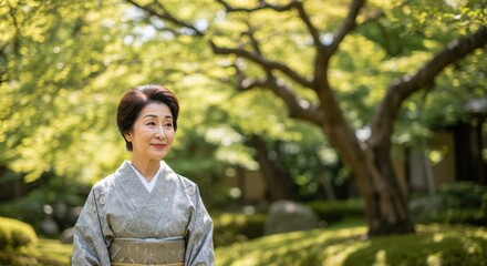 Elegant senior japanese woman in a traditional kimono smiling serenely in a lush green garden