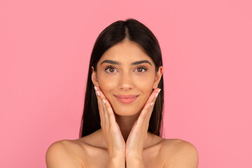 Smiling woman touching her cheeks gently, enjoying skincare moment. Promoting self love, softness...