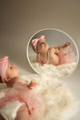 adorable baby with pink bow and pearls looks into mirror on fluffy white surface creating a charming and dreamy image with soft pastel colors and gentle lighting, captivating, portrait, intimate