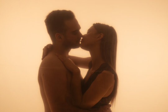 Intimate Moment Shared Between Couple Silhouetted in Warm Light