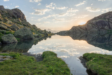 Stunning view of rocky Caucasus mountain peaks reflecting perfectly on a calm alpine lake at...