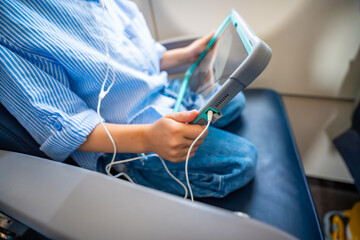 Close up view of little girl watching a cartoon on a tablet with headphones during an airplane...