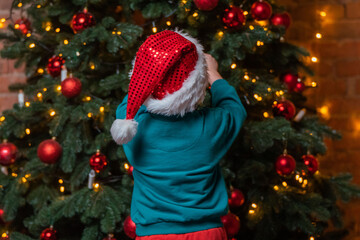 Child Decorating Christmas Tree with Ornaments, Festive Season Celebration