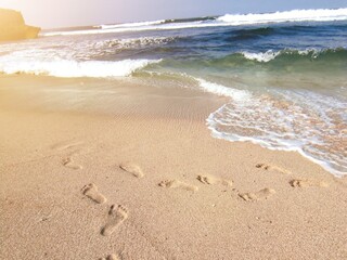Footprints in the Morning Sand by the Sea