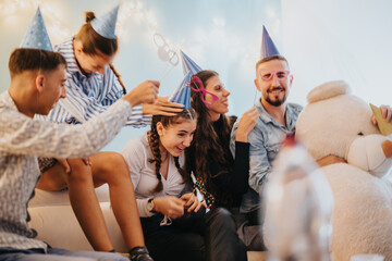 A joyful family gathering at home celebrating a birthday party with festive hats, playful masks,...