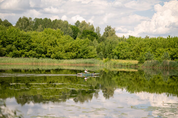 Kayaker paddling on calm scenic lake, enjoying peaceful summer day in nature
