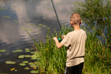 Blond boy fishing on colorful lake shore, enjoying summer day in nature with fishing rod