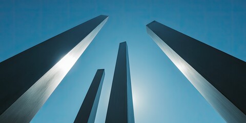 Abstract metal pillars against a clear blue sky