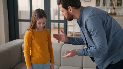 Annoyed Caucasian dad man father talk scream at offended little girl daughter kid at home angry...