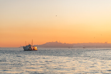 a transportation ship in bosphorus and golden sunset over istanbul historic peninsula