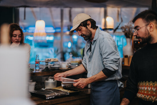 A group of three individuals engaging in tasks behind a bar, creating a dynamic and collaborative ambiance, surrounded by modern decor.