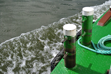 Mooring Posts and Bow Wave of Modern Passenger River Boat 