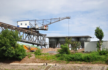 Riverside Industrial Site with Warehouses and Loading Crane