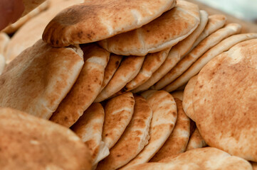 Pile of freshly baked round pita or pocket bread neatly ready for sale in the Machane Yehuda market in Jerusalem, Israel.