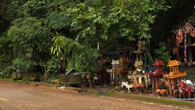 Colorful Thai spirit houses along jungle road in Chiang Dao, Thailand.