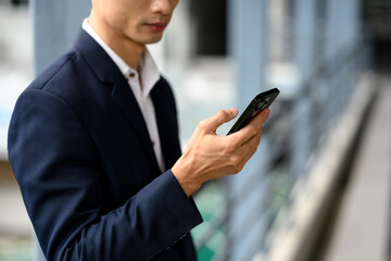 Smiling adult businessman with a phone in hand commuting to work