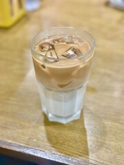 Unstirred iced latte — layers of espresso and milk beautifully separated, capturing the aesthetic...