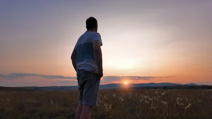 Fotobehang Chocoladebruin Silhouette of a man looking at the mountain sunset.  © astrosystem