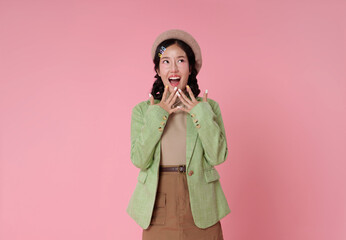 surprised and delighted Asian woman holds her hands to her face looking upwards with an open mouth...