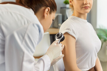 Patient arm skin and mole examination by dermatologist with dermatoscope in hospital. Doctor...