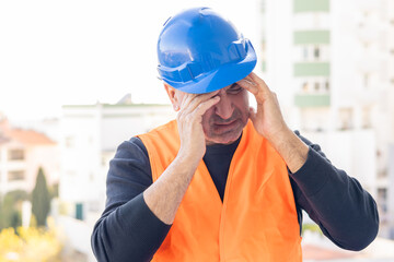 Tired and exhausted mechanical technician or building contractor. Bad news triggering headache