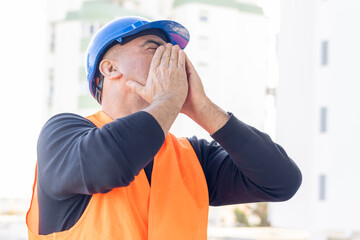 Tired and exhausted mechanical technician or building contractor. Bad news triggering headache