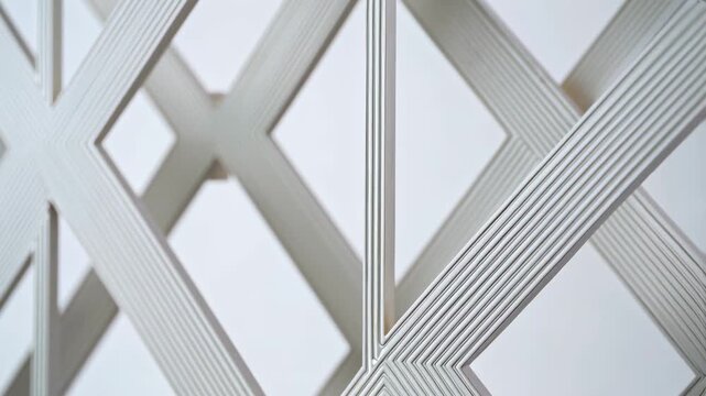 White abstract grid of parallel lines forming diamond and cross shapes on a simple background, looping footage.