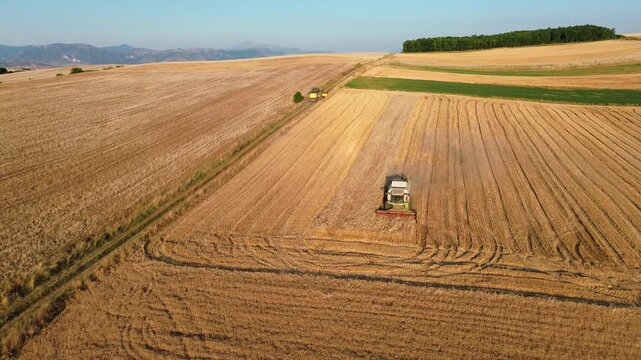 Agriculture hay mower tractor tedder modern field work rural village, aerial drone fieldwork labour