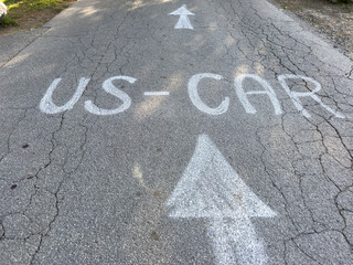 Road surface with cracked asphalt and painted directions for us car traffic
