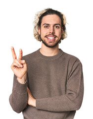 Young Caucasian man in studio setting showing number two with fingers.