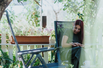 A young girl plays with a lizard in a vibrant garden setting, seated comfortably and enjoying the...