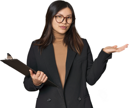 Chinese businesswoman holding inventory list showing a copy space on a palm and holding another hand on waist.