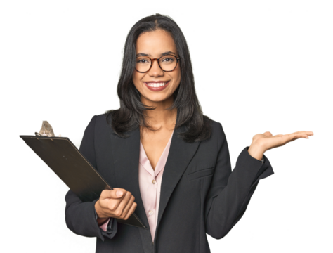 Latina businesswoman holding a report showing a copy space on a palm and holding another hand on waist.