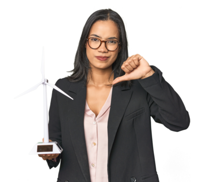 Latina holding a windmill, eco energy showing a dislike gesture, thumbs down. Disagreement concept.