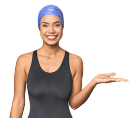 Pro Latina swimmer in studio gear showing a copy space on a palm and holding another hand on waist.