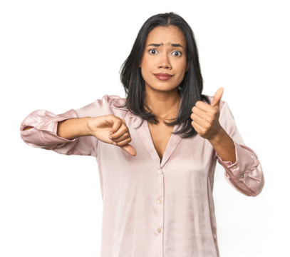 Simple portrait of a young Latina showing thumbs up and thumbs down, difficult choose concept
