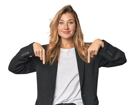 Young businesswoman in a suit points down with fingers, positive feeling.
