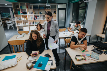 A dynamic classroom scene with a teacher assisting students. The space is filled with natural...