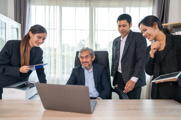 Business team collaborating during office meeting while discussing ideas with laptop and documents, showing teamwork, leadership and communication, working together on business strategy and planning