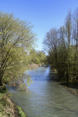 Arlazon River flowing through trees and city buildings in Burgos